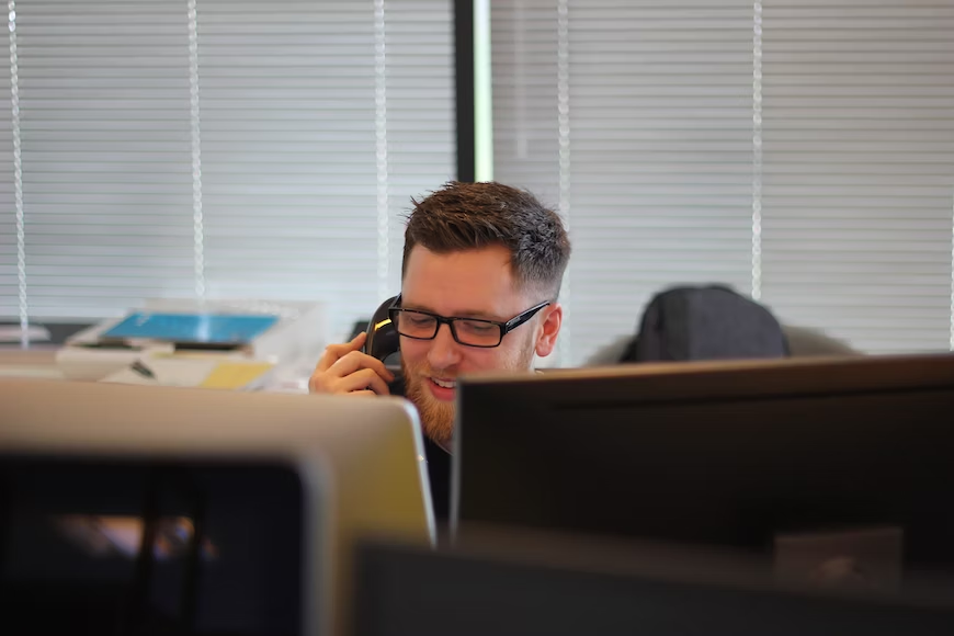 Man talking to customers on the phone in front of computer monitors - inbound marketing - Shift4Shop