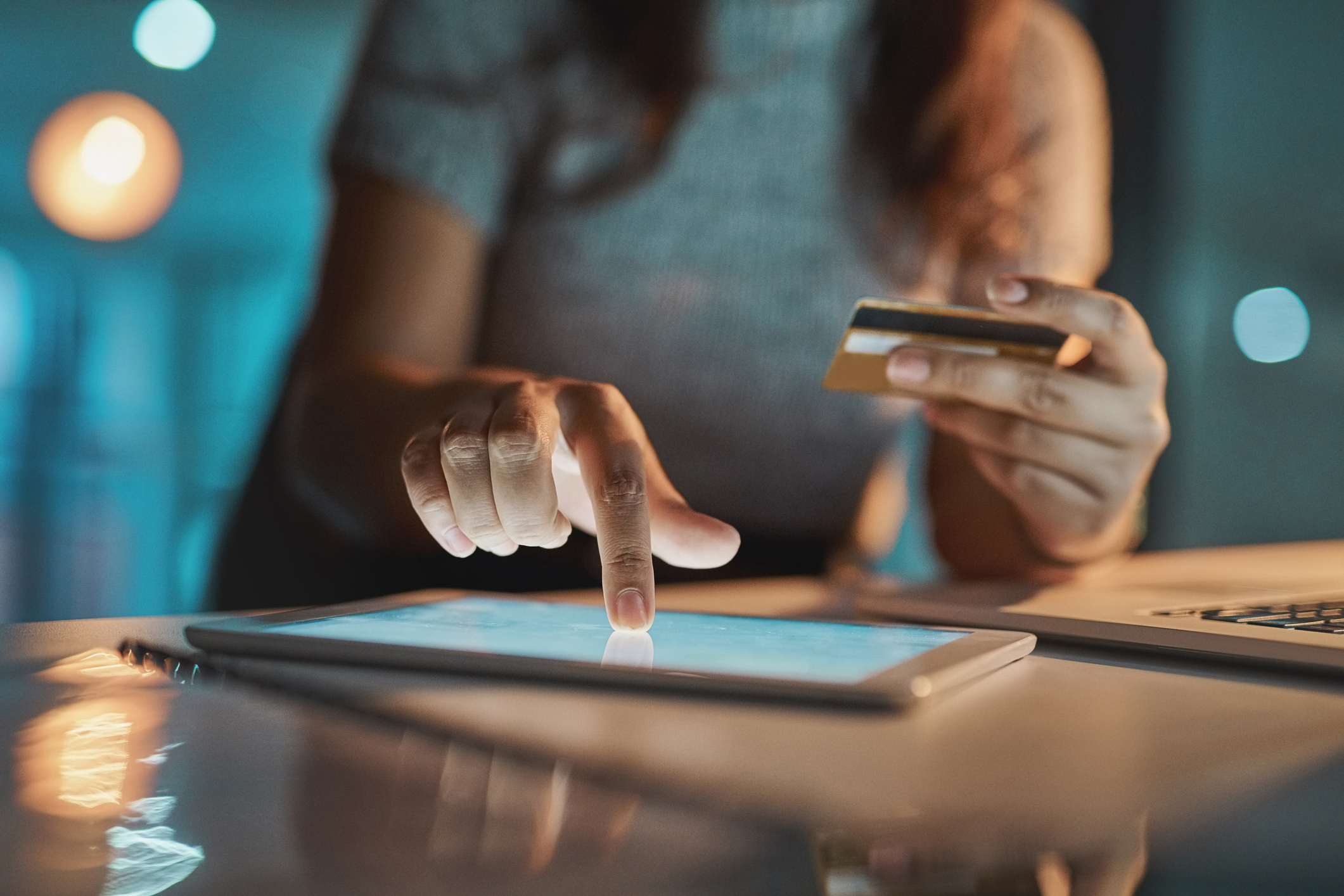 Women pressing on tablet with finger while holding phone.