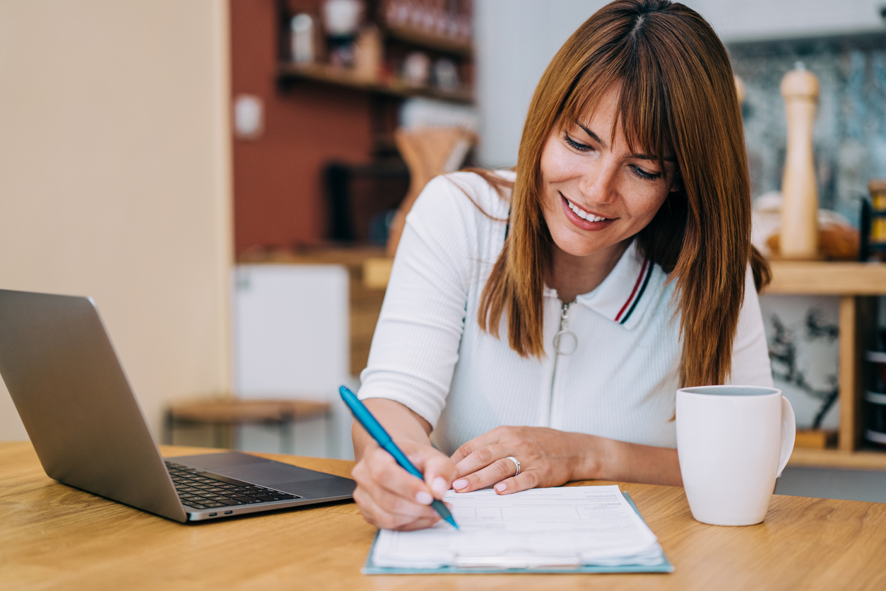 Woman filling out a legal business policy document for her eCommerce business - Shift4Shop