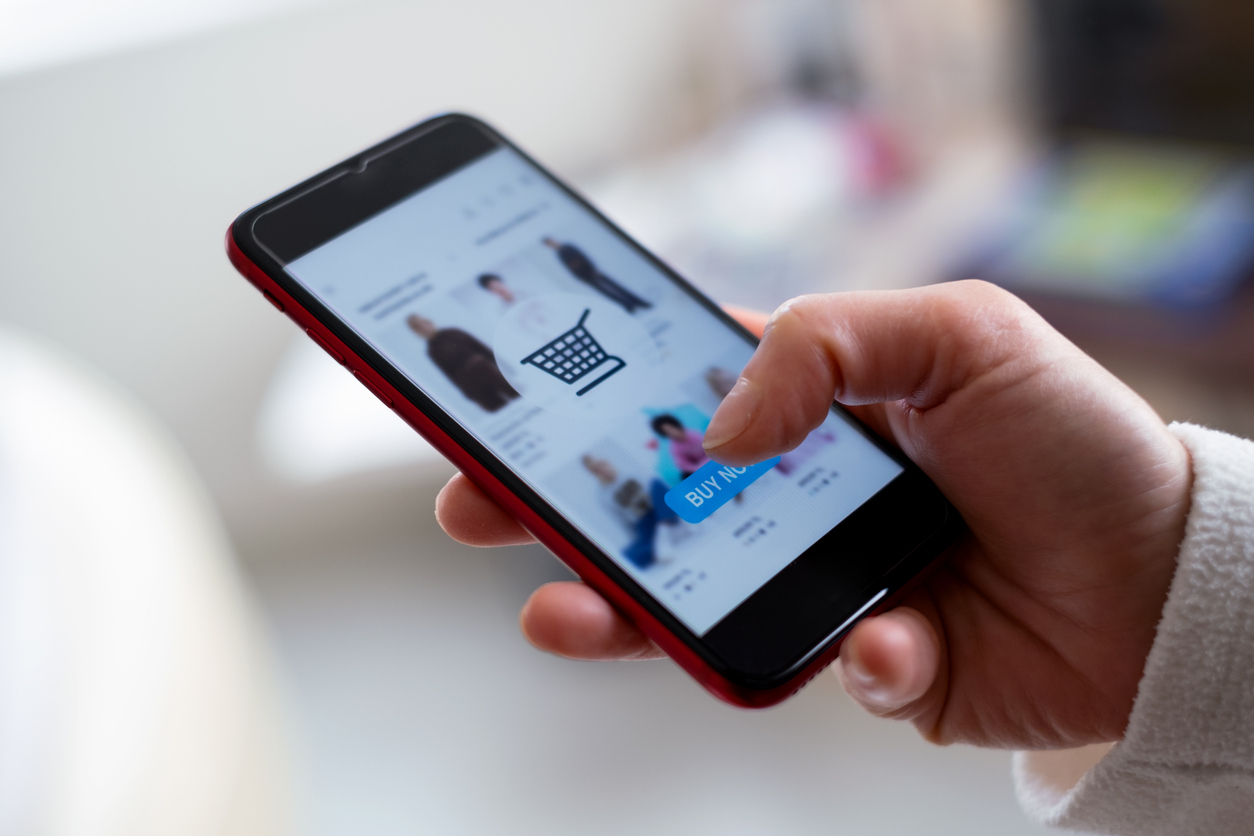 Customer using a smartphone to shop online, representing an eCommerce customer touchpoint - Shift4Shop